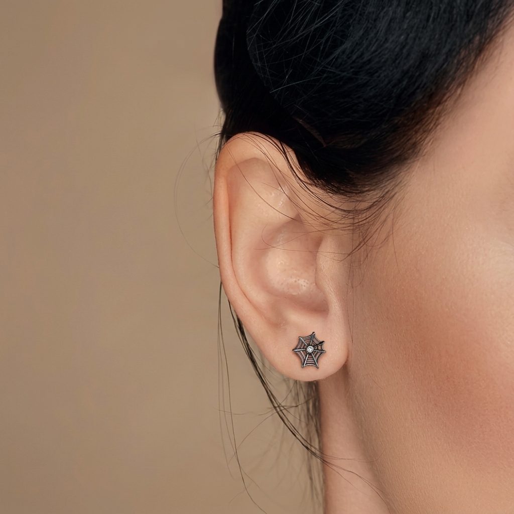 Black spiderweb cartilage stud earring with a sparkling cubic zirconia center stone