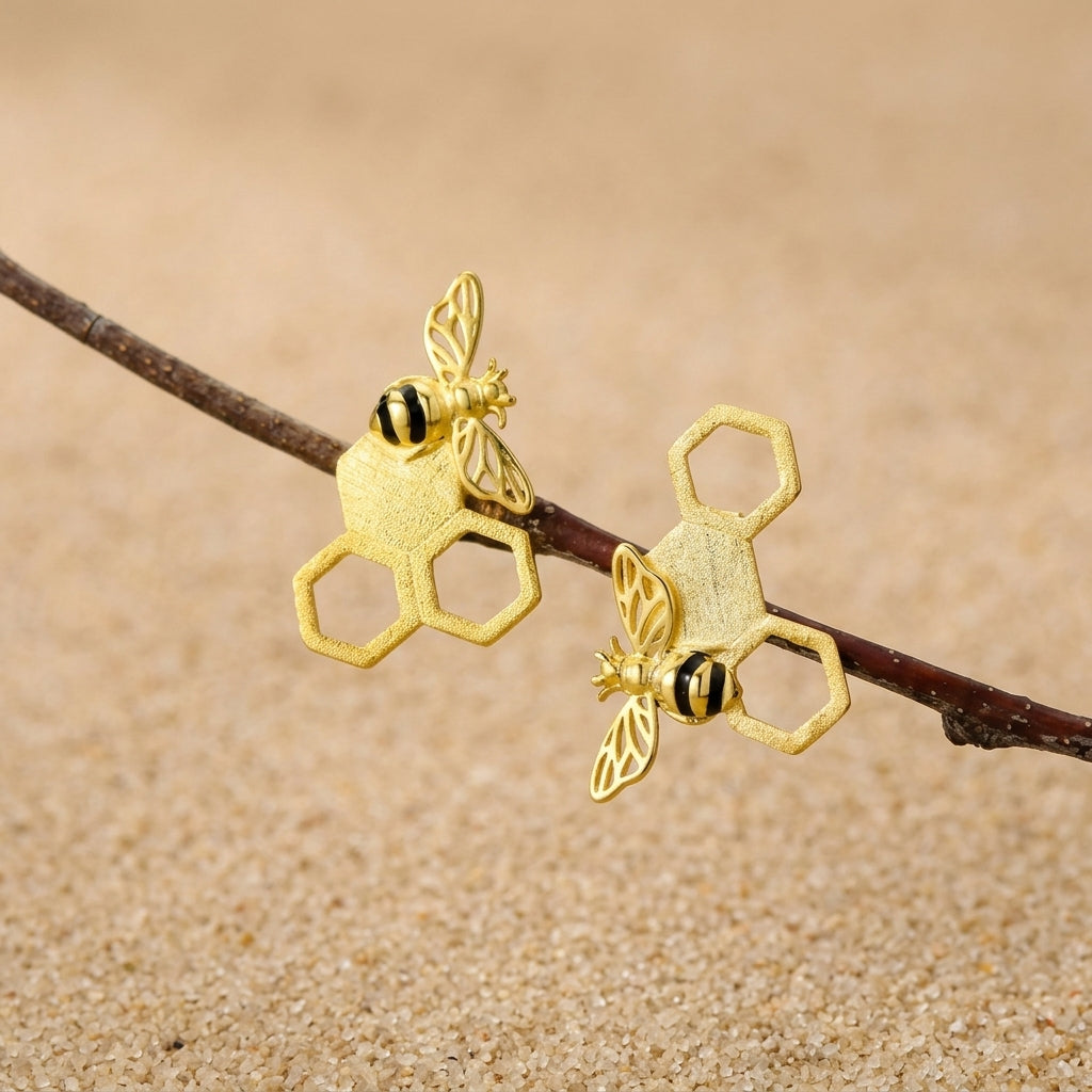 18kt gold plated bee earrings featuring a realistic honey bee perched on a textured honeycomb geometric design