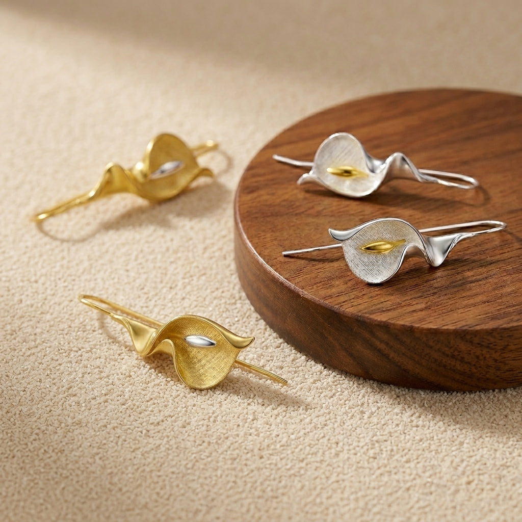 artisan Calla Lily earrings, highlighting the smooth gold-plated petals and delicate silver stem craftsmanship.