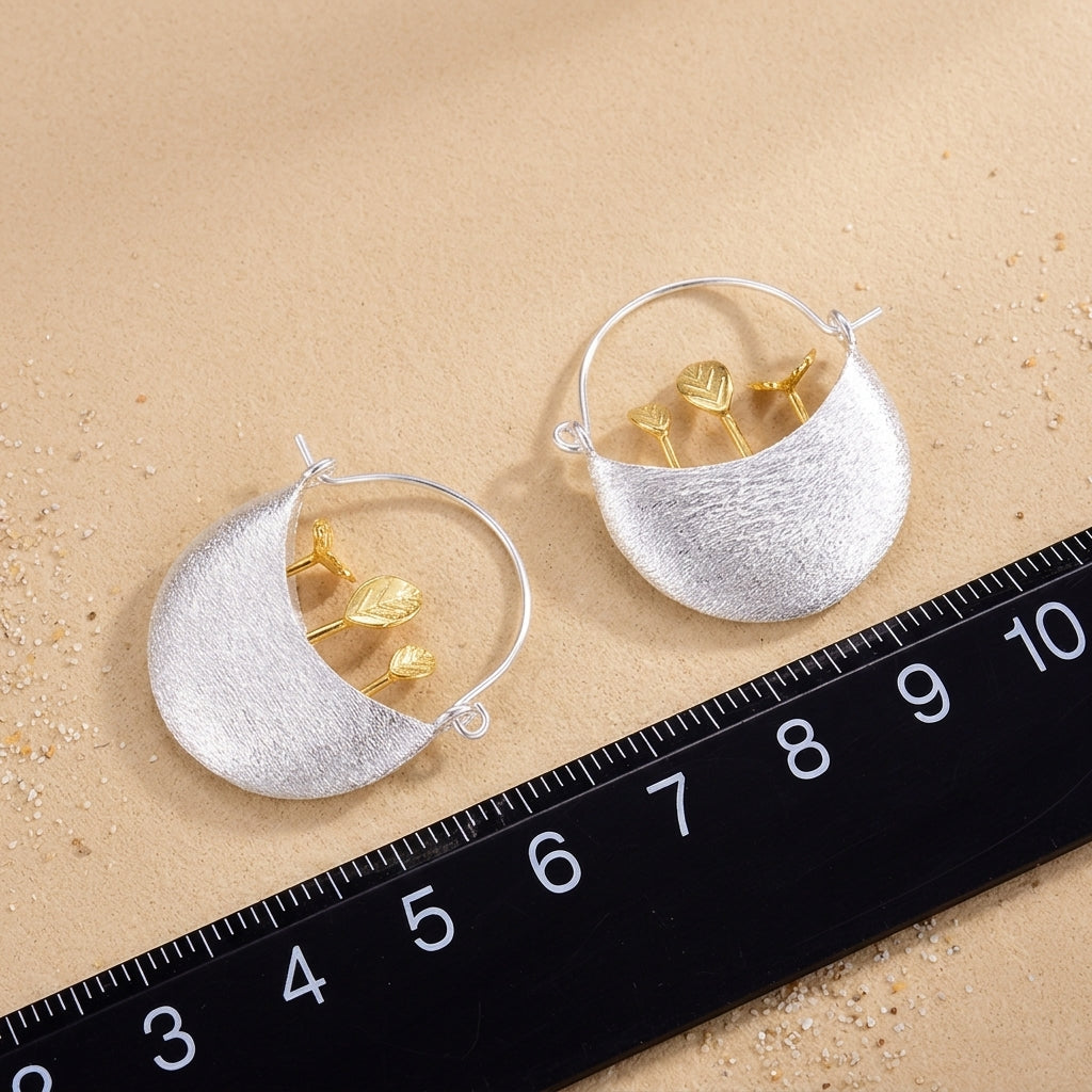 Macro view of 18kt gold flower pot earring charms with fine silver detailing, highlighting the artisanal garden-inspired textures.