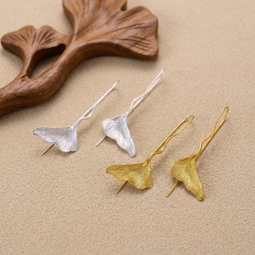 18kt gold plated sterling silver Ginkgo leaf earrings reflecting warm natural light.