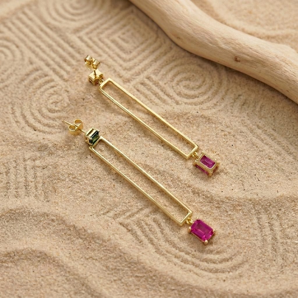 Geometric gold-plated drop earrings with green cubic zirconia stud and pink charm, close detail