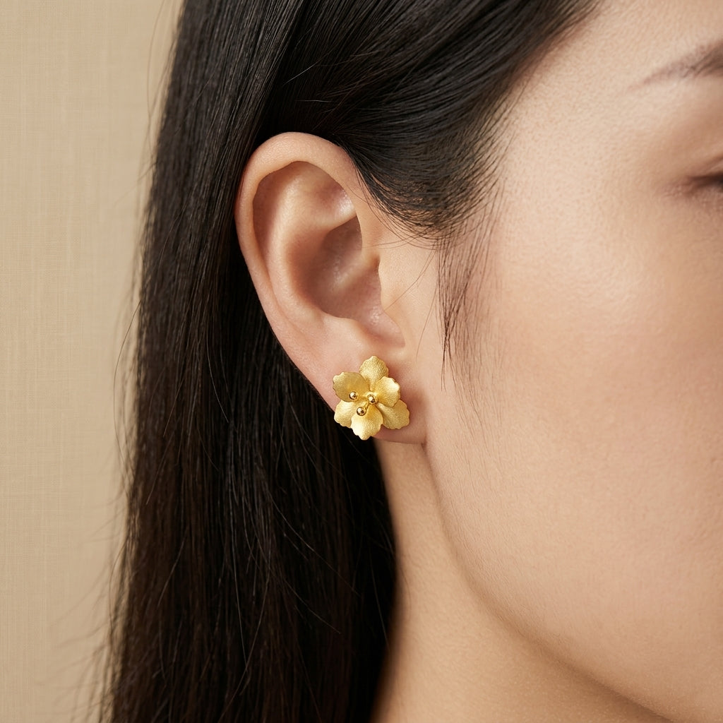 Model wearing realistic 18kt gold and silver floral studs to show the dainty scale and natural sculptural fit