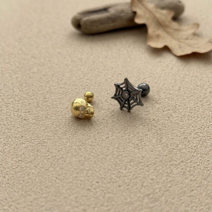 3D skull and spiderweb cartilage stud earrings in gold and black oxidized finish