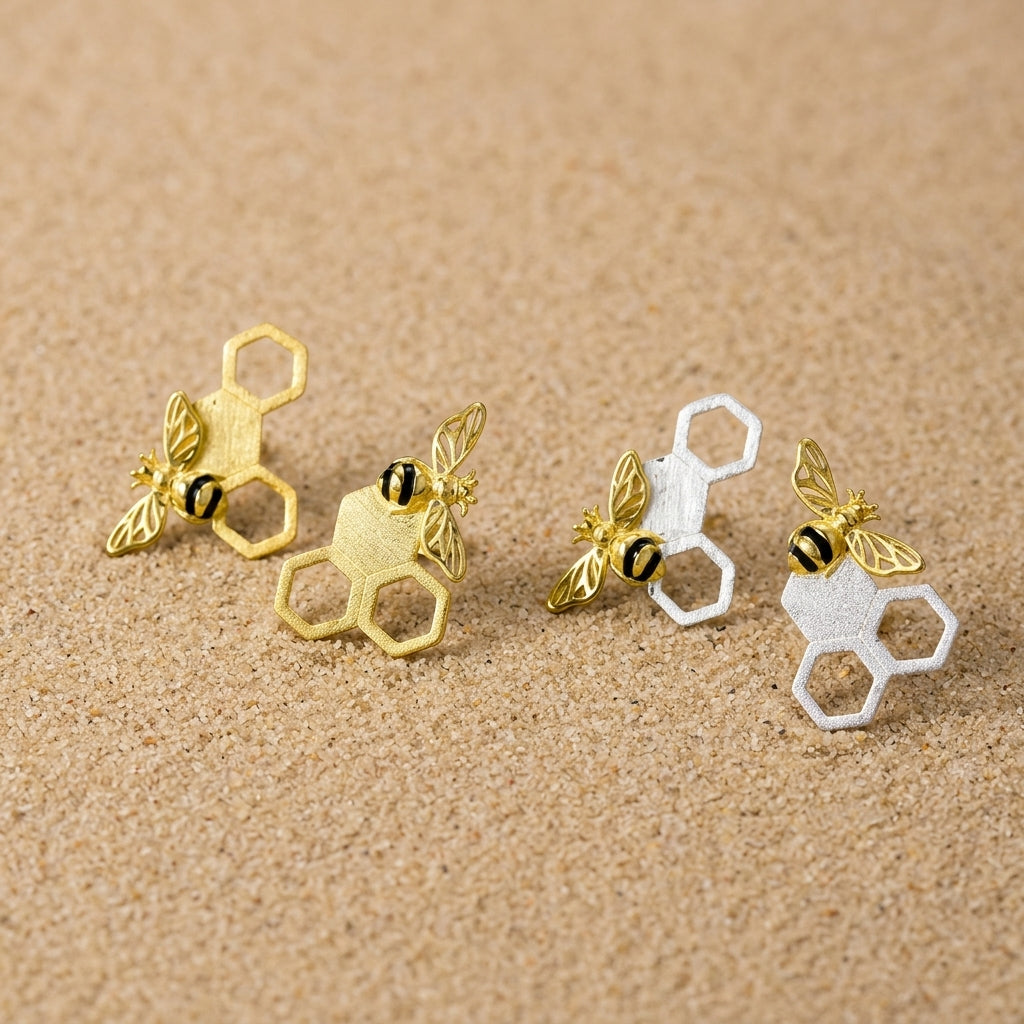 Side-by-side view of bee on honeycomb earrings in both sterling silver and 18kt yellow gold plated finishes