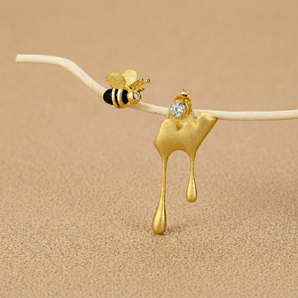 Asymmetrical bee and honey drip earrings set in 925 sterling silver with 18kt gold plated accents for a unique nature-inspired look