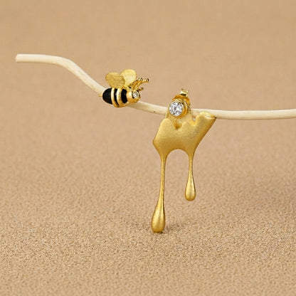 Asymmetrical bee and honey drip earrings set in 925 sterling silver with 18kt gold plated accents for a unique nature-inspired look