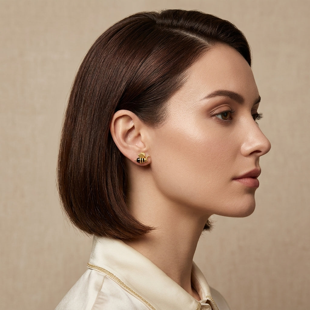 Close-up of the 3D gold-plated bee stud earring showing realistic wing texture and a high-polish sculptural body