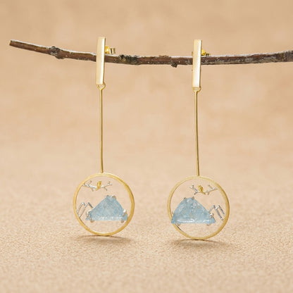 18kt gold-plated sterling silver circular dangle earrings featuring a delicate bird on a branch with a scenic mountain backdrop