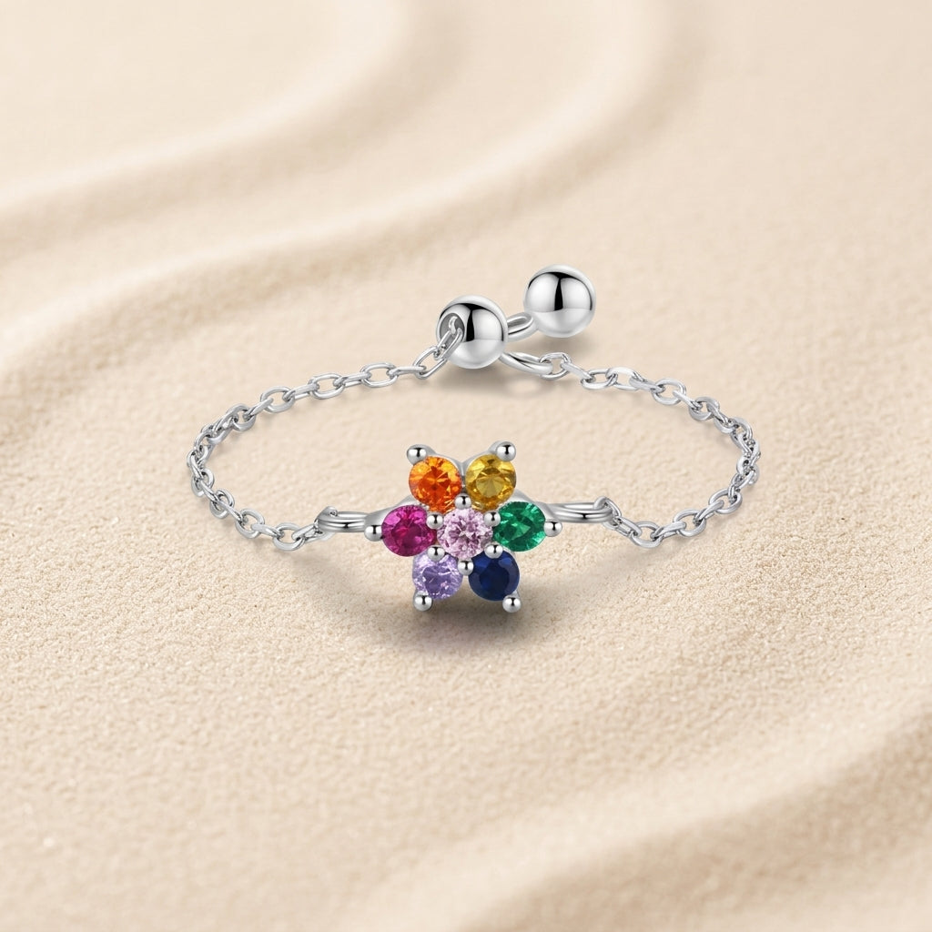 Resizable sterling silver chain ring with a colorful zirconia flower, adjustable fit for any finger size.