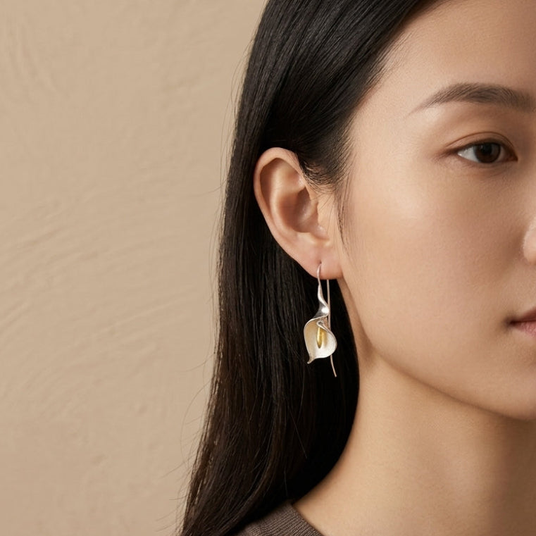 Elegant Calla Lily dangle earrings in 18kt gold plated sterling silver, featuring a graceful curved floral silhouette.