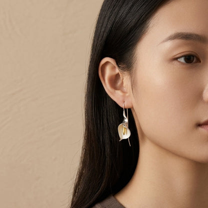 Elegant Calla Lily dangle earrings in 18kt gold plated sterling silver, featuring a graceful curved floral silhouette.