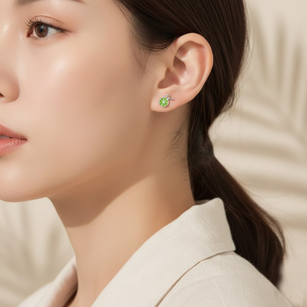Small green apple earring on ear showing dainty fit and safe screw-back for comfortable daily wear