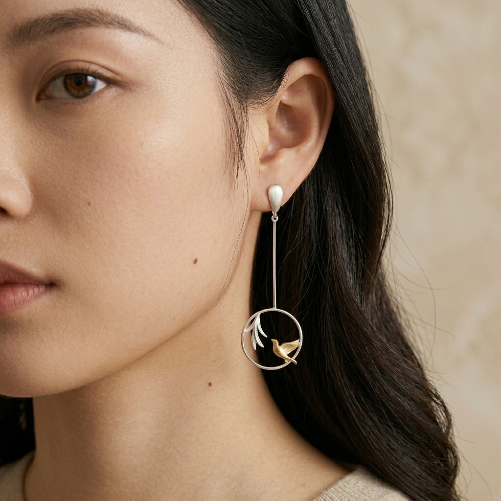 Model wearing long, lightweight Humming Bird drop earrings, showing the elegant movement and nature-inspired botanical design