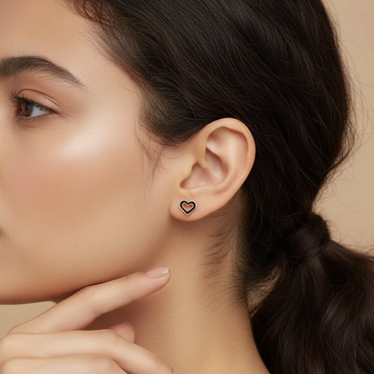 Model wearing a petite gold heart stud earring, showing the dainty scale of these sterling silver jewelry pieces.