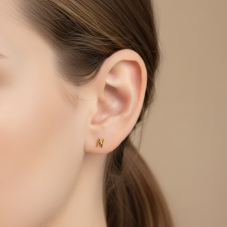 Gold initial stud earring on model, dainty sterling silver personalized jewelry gift for women and kids.