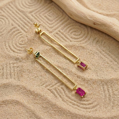 Geometric gold-plated drop earrings with green cubic zirconia stud and pink charm, close detail