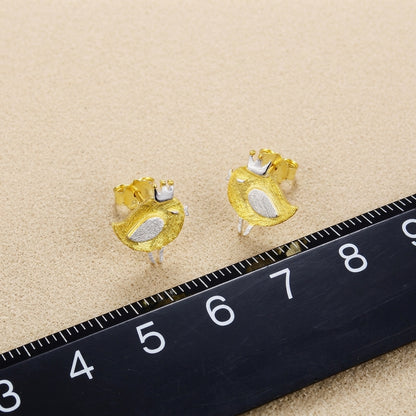 Side profile of a model wearing tiny 18kt gold bird studs to demonstrate the dainty scale and comfortable fit on the earlobe