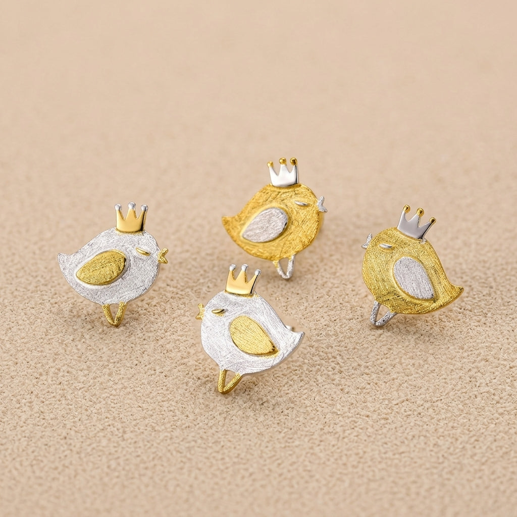 Comparison shot of the tiny bird design earrings available in both polished sterling silver and 18kt gold plated finishes