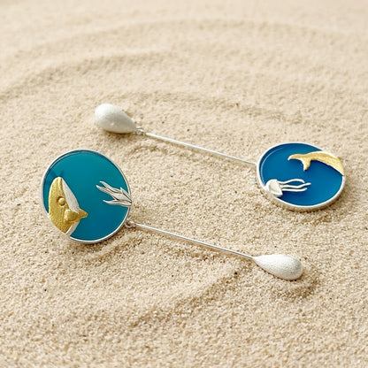 long silver whale and jellyfish drop earrings, showcasing the elegant movement and vibrant blue agate stones